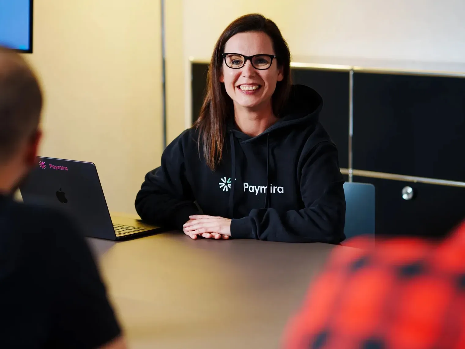 Ein Mitglied des Paymira-Teams im Gespräch am Besprechungstisch
